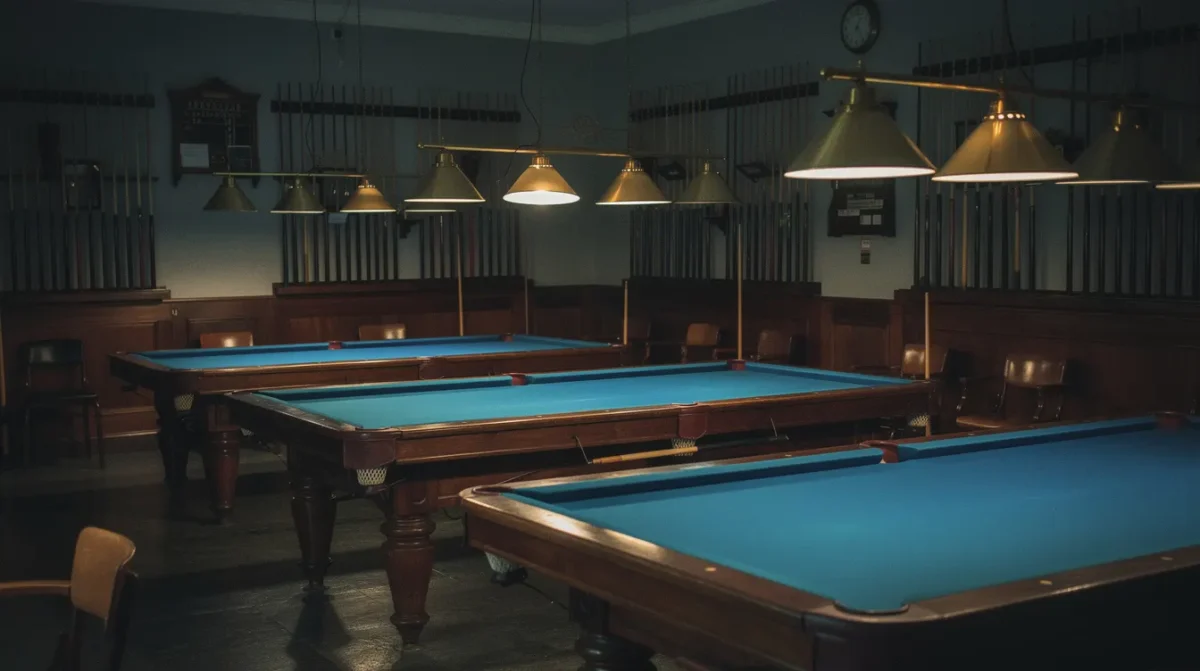 Salle de billard français la nuit, tables en drap bleu sous les lampes